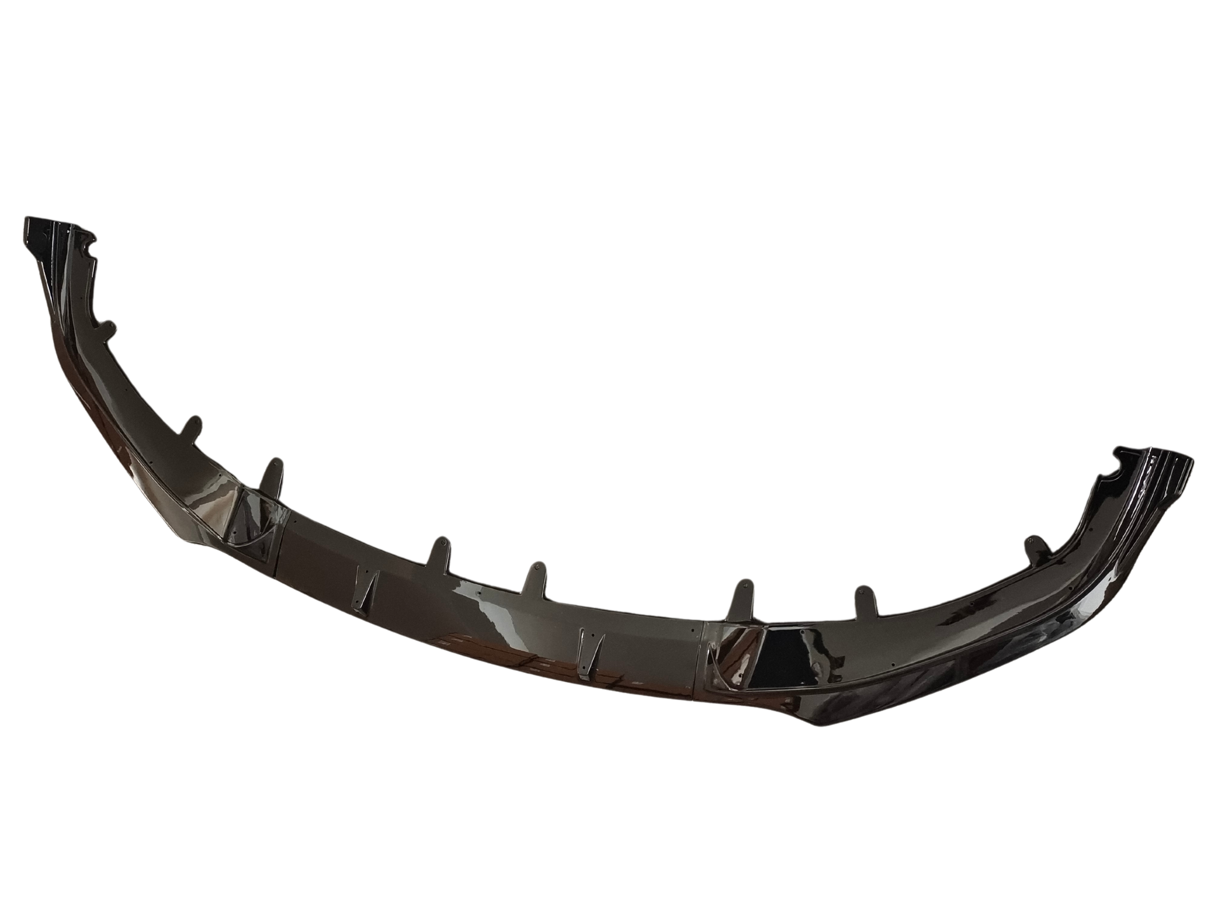 A glossy black car front splitter, featuring several vertical fins, is displayed against a plain white background, highlighting its aerodynamic design for vehicle use.