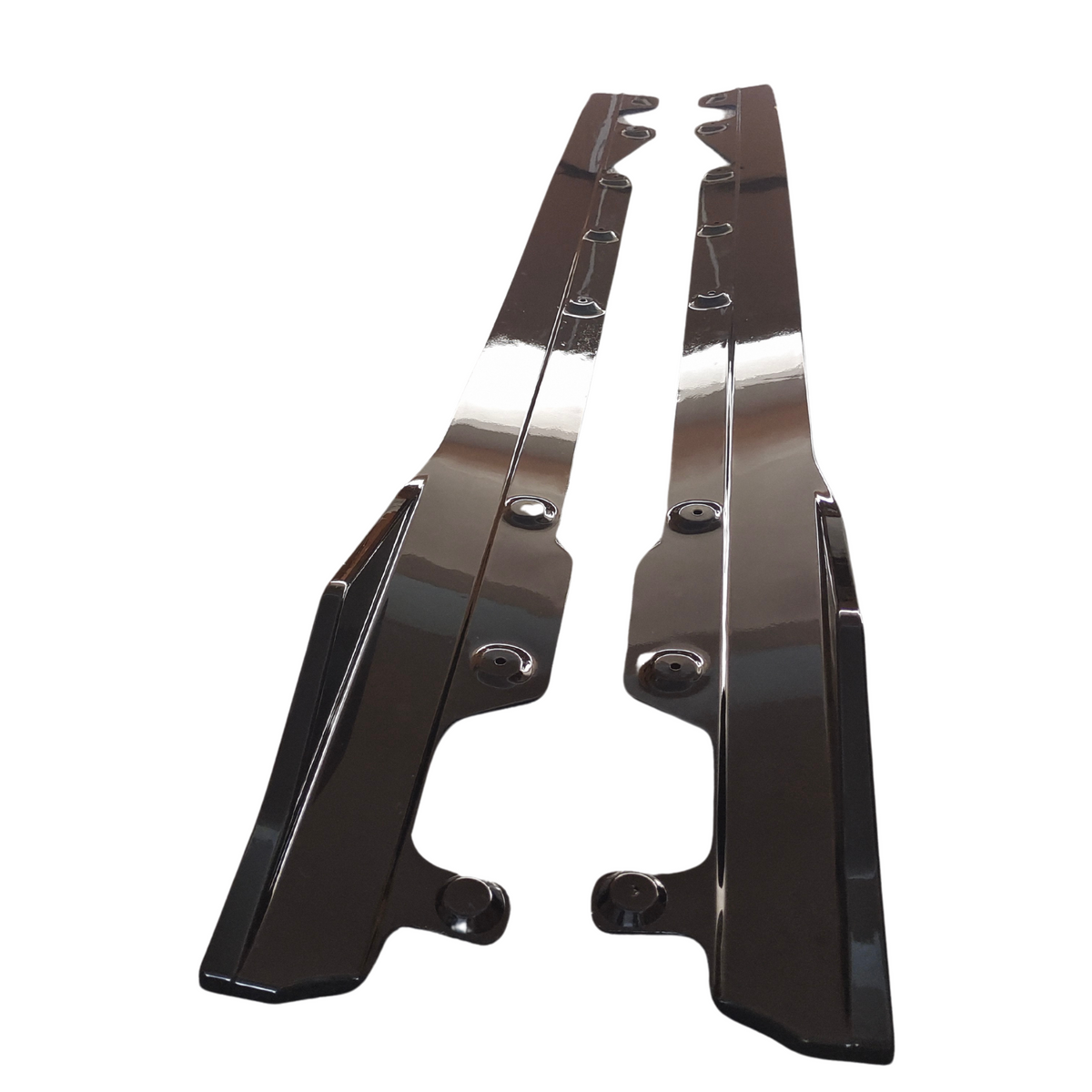 Two glossy, black car side skirts lie parallel on a plain white surface, each featuring pre-drilled holes for mounting.