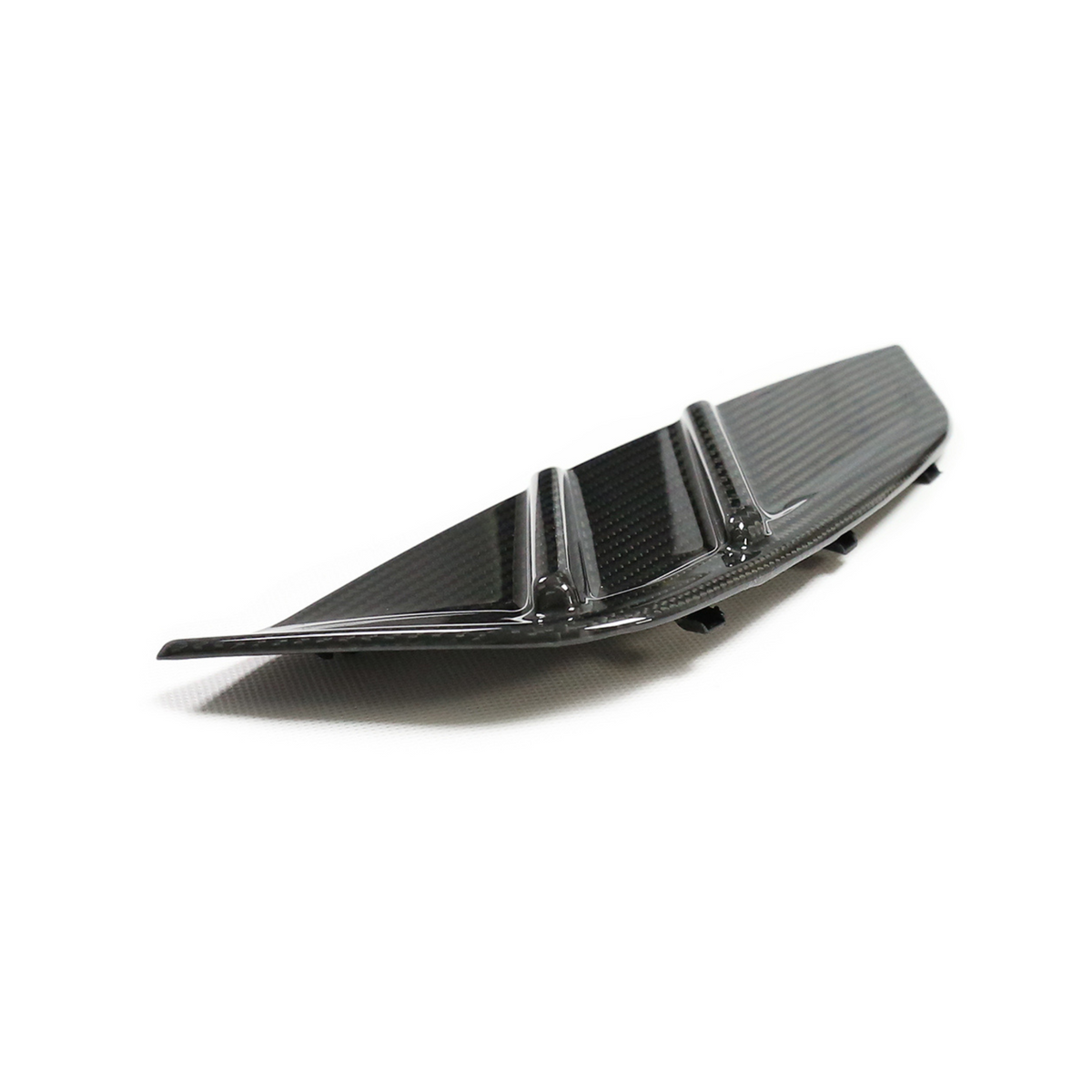 A sleek, black carbon fiber car rear diffuser with vertical fins rests on a white surface, suggesting its use for aerodynamic enhancement.