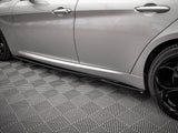 A silver car with black wheels is parked on a patterned, interlocking gray floor. The side profile emphasizes its sleek design and closed doors, with no text visible.