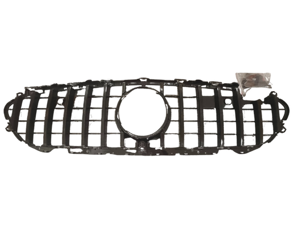 A black car grille with a central circular opening is laid on a plain white background. A small plastic bag containing screws is near the right side of the grille.