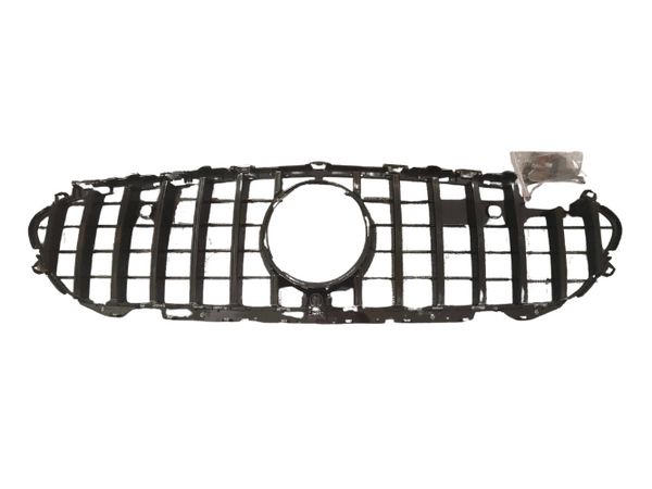 A black car grille with a central circular opening is laid on a plain white background. A small plastic bag containing screws is near the right side of the grille.