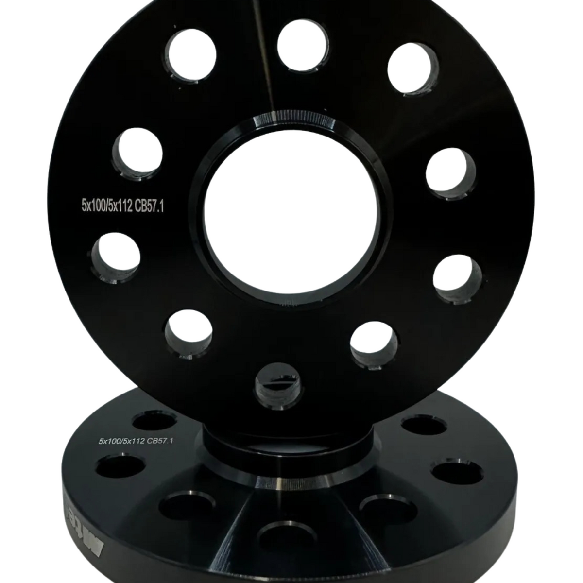 Two black, circular metal wheel spacers with multiple evenly spaced holes, stacked vertically. Text reads “5x100/5x112 CB57.1.” The background is plain white, emphasizing the products.