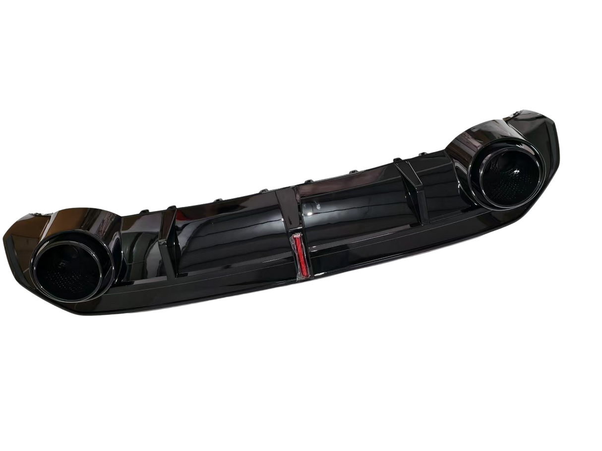 A glossy black car bumper with two circular exhaust openings is displayed against a white background.
