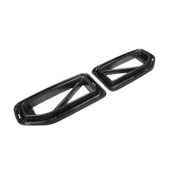 Two rectangular carbon fiber air vents lie flat, showcasing a sleek, glossy finish. The vents feature diagonal supports within a white, seamless background.