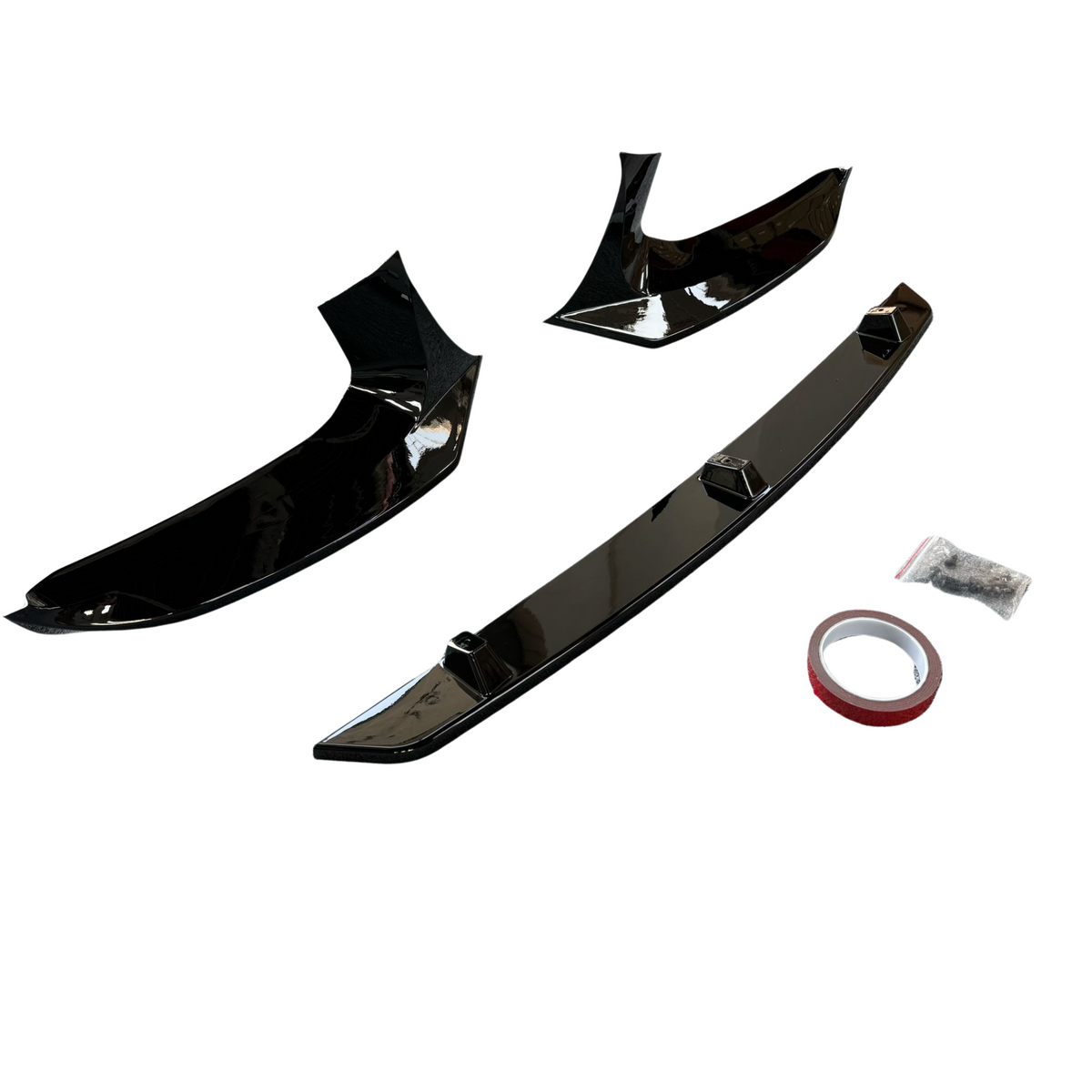Black car splitter parts, positioned separately, include curved sections and a rod. Accompanied by adhesive tape and a small bag, set against a plain white background.
