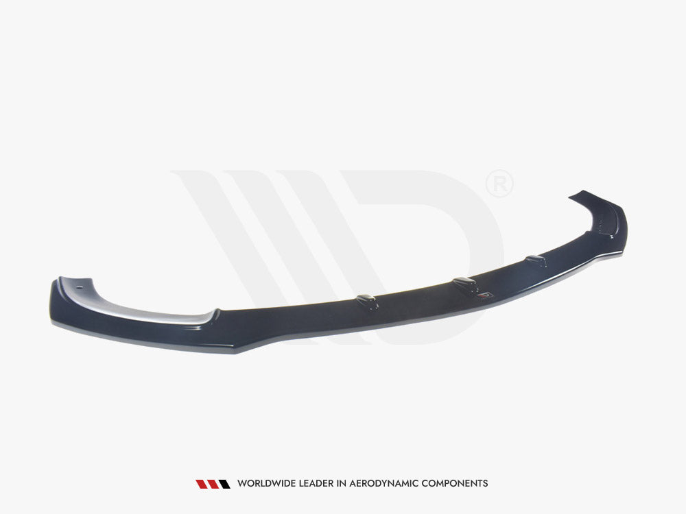 A black aerodynamic car component, resembling a front splitter, rests on a plain white background. Text below reads: "WORLDWIDE LEADER IN AERODYNAMIC COMPONENTS."