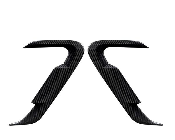 Two carbon fiber car door handles positioned symmetrically, facing each other against a white background, showcasing their sleek, contoured design and smooth texture.