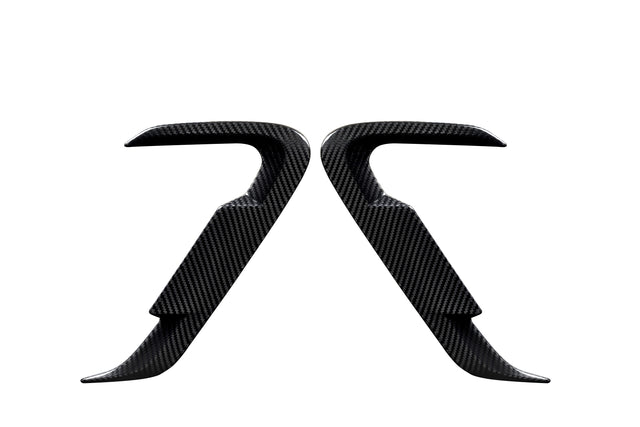 Two carbon fiber car door handles positioned symmetrically, facing each other against a white background, showcasing their sleek, contoured design and smooth texture.