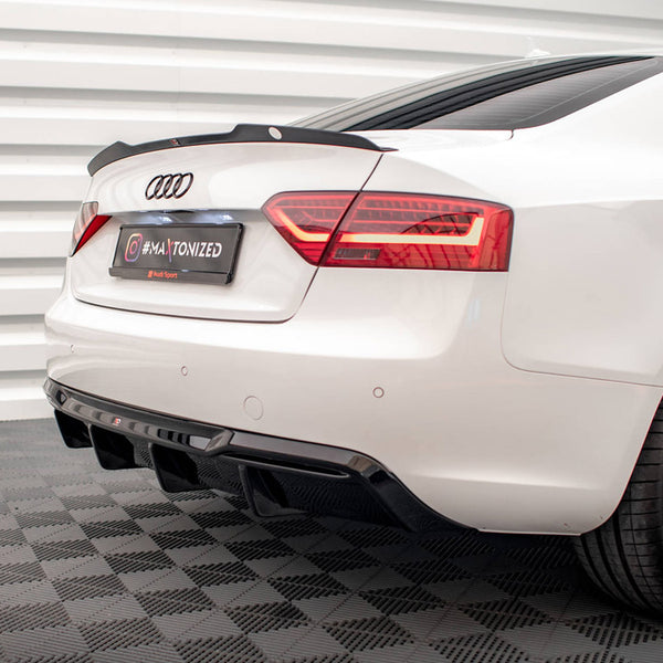 Car with sleek rear design, featuring tinted taillights and dual exhaust, parked on patterned floor. License plate reads "#MAXTONIZED @Maxton Design." White wall paneling provides a modern backdrop.