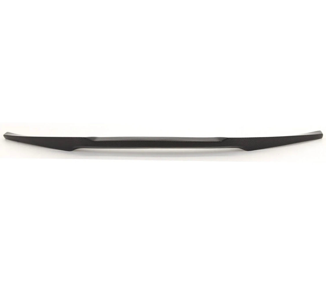 A long, sleek, black object, possibly an automotive accessory or trim piece, lies horizontally against a plain white background.