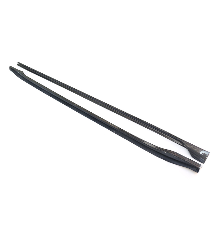 Two long, black carbon fiber strips lie parallel on a white surface, showcasing a sleek, textured appearance suitable for automotive or structural applications.