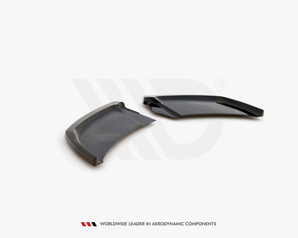 Two sleek, aerodynamic black plastic components rest on a white surface, angled adjacent to each other. Text below reads: "WORLDWIDE LEADER IN AERODYNAMIC COMPONENTS."