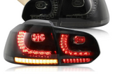 Tail lights with red and amber LED lights illuminated, placed near a cardboard box in a bright setting. The brand name 