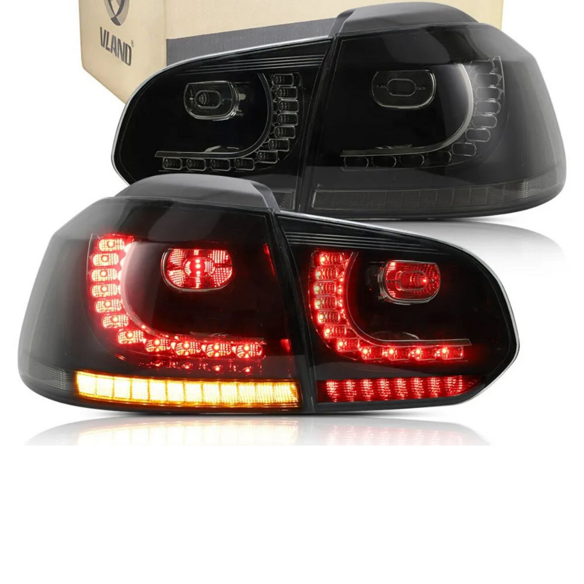 Tail lights with red and amber LED lights illuminated, placed near a cardboard box in a bright setting. The brand name "VLAND" is printed on the box.