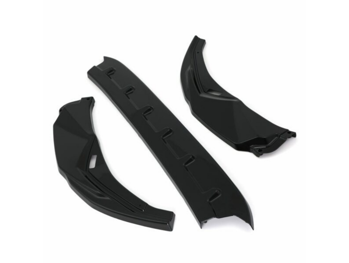 Three black car parts, possibly aerodynamic components, are arranged on a white background. Two pieces are angled with a geometric design, and one is a straight, ribbed section.