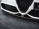 Car grille with a V-shaped design and black mesh pattern, positioned close to the ground. The left side shows a sensor. The floor has a textured geometric pattern.