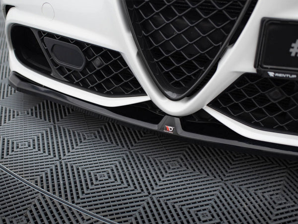 Car grille with a V-shaped design and black mesh pattern, positioned close to the ground. The left side shows a sensor. The floor has a textured geometric pattern.