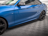 A blue sports car with sleek, aerodynamic lines is parked on a textured gray floor inside a modern, well-lit garage.