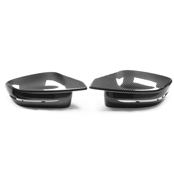 Two carbon fiber car mirror covers rest side by side on a white surface, showcasing their sleek, aerodynamic design and glossy finish.