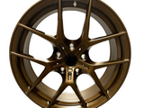 Bronze-colored alloy wheel with multiple thin spokes radiating from a central hub, displayed against a plain white background, showcasing its sleek, modern design.