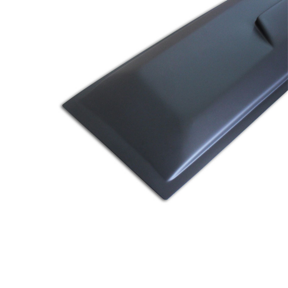 A dark, angular, and sleek object, possibly a protective cover or panel, rests on a plain, light gray background, showing its smooth surface and defined edges.