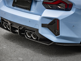 A light blue car with sporty dual exhaust pipes and a carbon fiber diffuser is parked on a paved surface. The rear taillights have an angular design.