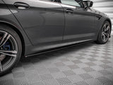 A sleek, grey car parked on a textured, patterned floor inside a well-lit garage, highlighting its elegant design features and alloy wheels.