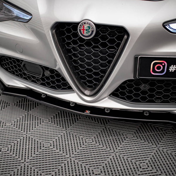 Car front with Alfa Romeo badge and honeycomb grille, parked on a patterned floor. License plate displays "@MAXTUNE" with Instagram logo.