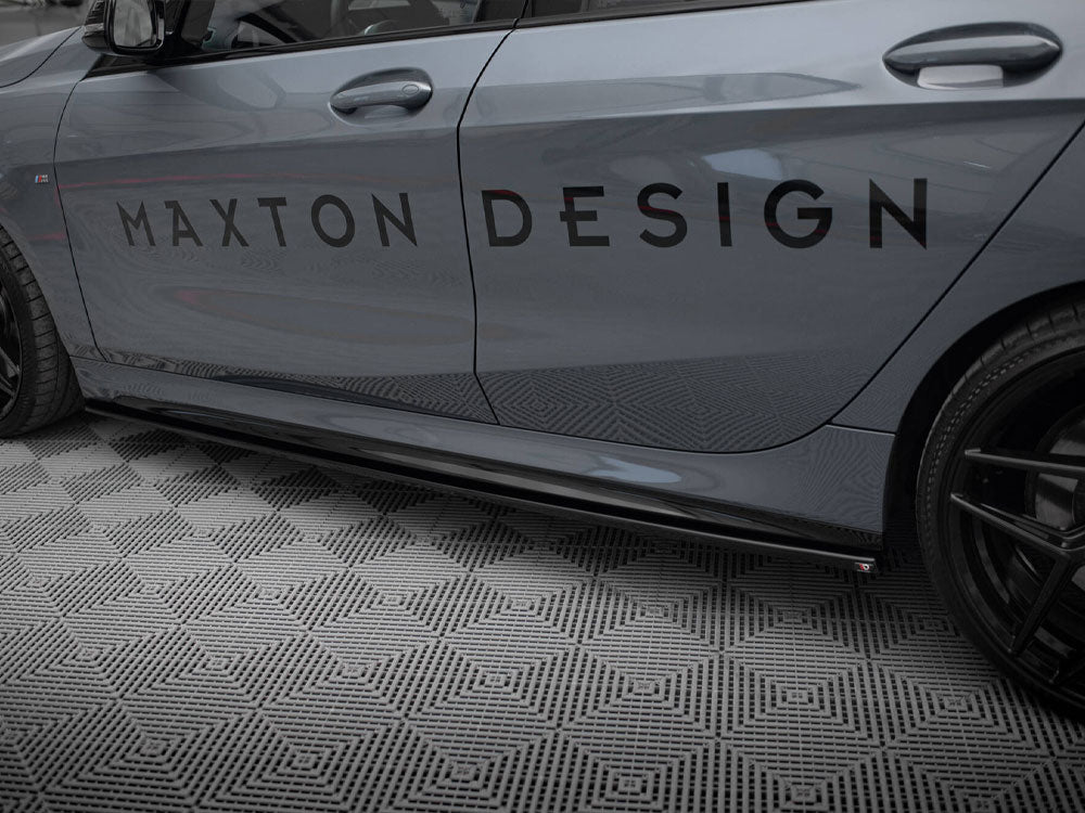 Car side displaying the text "MAXTON DESIGN" on its door, parked on a diamond-patterned floor. The vehicle is grey with black wheels, shown in a garage setting.