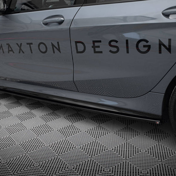 Car side displaying the text "MAXTON DESIGN" on its door, parked on a diamond-patterned floor. The vehicle is grey with black wheels, shown in a garage setting.