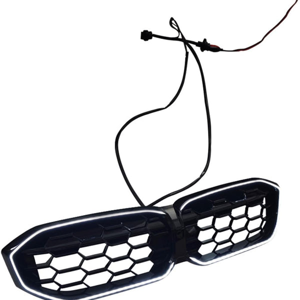 A black, hexagonal-patterned car grille with LED lights is connected to two wires. It is set against a plain white background.
