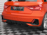 A red Audi A1 is parked on a checkered floor, displaying a black 