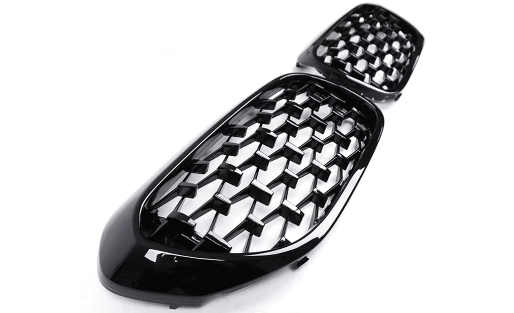A pair of glossy black honeycomb-patterned car grilles are displayed on a plain white background, showcasing a modern and sleek design intended for automotive use.