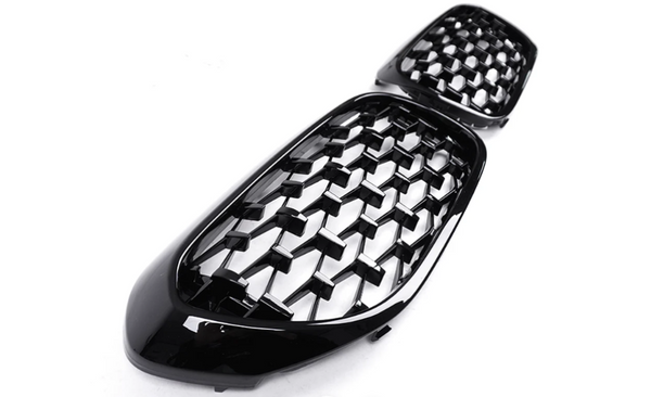 A pair of glossy black honeycomb-patterned car grilles are displayed on a plain white background, showcasing a modern and sleek design intended for automotive use.