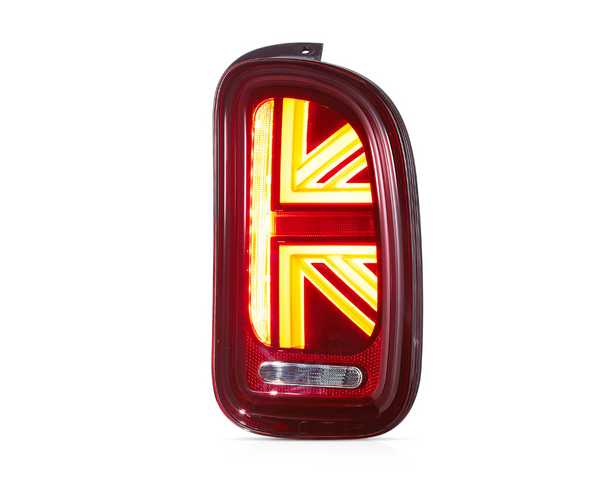 A red car taillight shaped like a Union Jack is illuminated brightly, positioned against a plain white background.