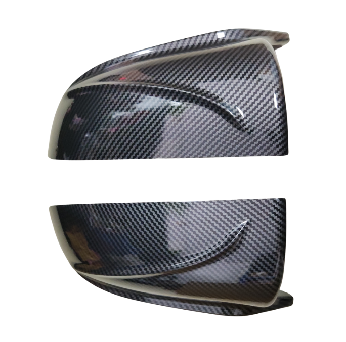 Two carbon fiber-patterned automotive mirror covers are positioned horizontally on a white background, showcasing their glossy finish and curved design, reflecting light and surroundings.