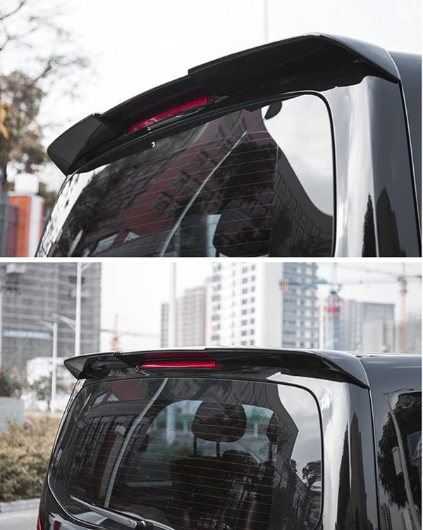 A black car rear spoiler with an integrated red brake light, attached above the rear window. The car is parked outdoors in a city area with buildings in the background.