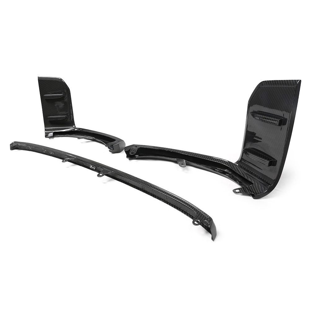 Carbon fiber car aerodynamic parts, including a splitter and winglets, rest on a white background. These components feature sleek, glossy surfaces with a textured, woven pattern.