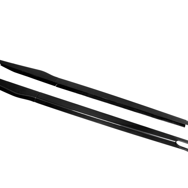 Two elongated carbon fiber side skirts, featuring a sleek design, rest parallel on a plain white background.