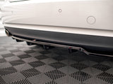 The rear of a white car with parking sensors is displayed, showcasing a black diffuser and exhaust pipes. It is situated on a checkered-patterned floor.