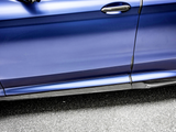 A blue car door with a carbon fiber handle and trim features an 