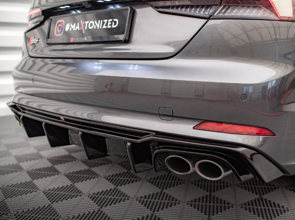 A sporty car's rear features dual exhaust pipes and sleek bumper design in a well-lit garage. Text: "#MAXTONIZED" on the license plate region and "S5" badge on the trunk.