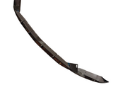 A sleek, black car bumper lip with angled segments resting on a white background, featuring a hole for attachment, likely enhancing vehicle aerodynamics.