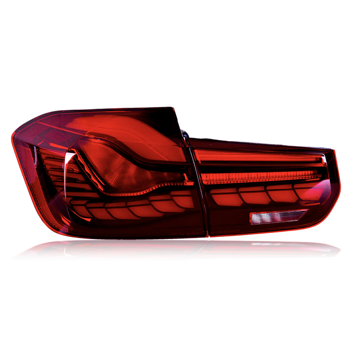 A car taillight is illuminated brightly, featuring a red and intricate design. The taillight is isolated against a plain white background, highlighting its sleek and modern curves.