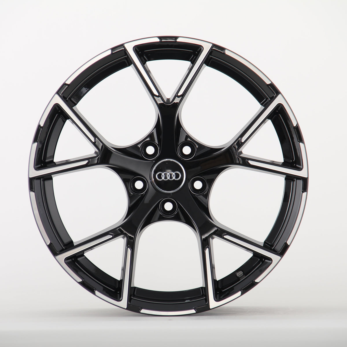 A sleek black alloy wheel with a glossy finish and five split spokes, featuring the Audi logo in the center, displayed against a plain white background.