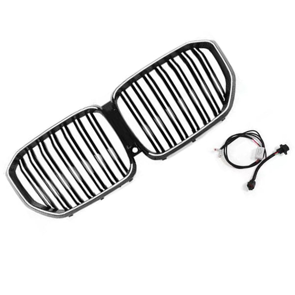 A dual-section car grille with vertical bars, black and chrome, lies on a white surface. Nearby, a black electrical cable with connectors rests, suggesting installation use.