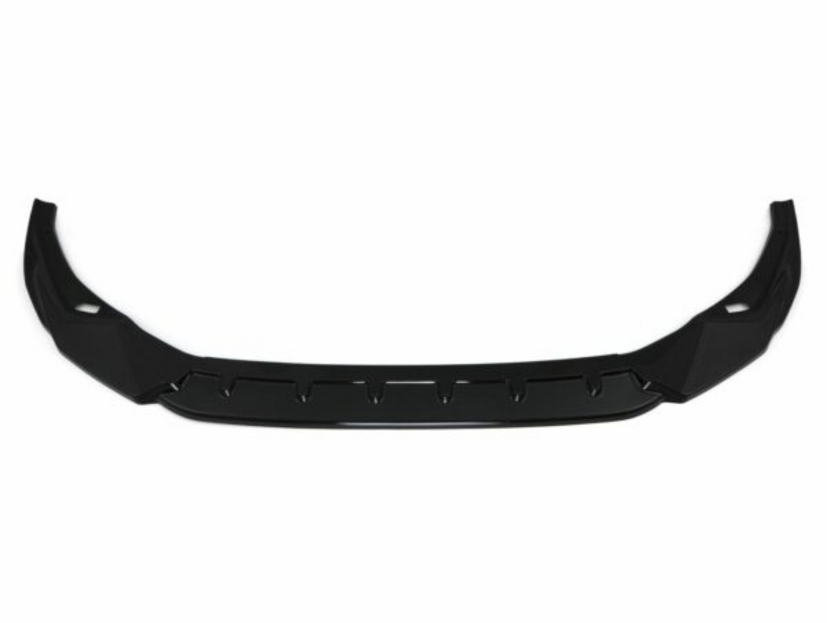 A black car front lip spoiler, featuring an angular, aerodynamic design, lies against a plain white background, emphasizing its sleek structure.
