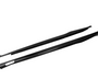 Two black carbon-fiber side skirts lie parallel, showcasing sleek design and aerodynamic shape against a plain white background.