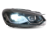 A car headlight shines brightly, encapsulated in a transparent casing, showcasing modern angular design elements. The background is plain white, emphasizing the headlight's features.